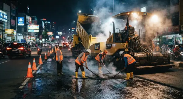 kontraktor jalan dari PT. Mitra Jalan Raya mengerjakan proyek aspal jalan pada malam hari